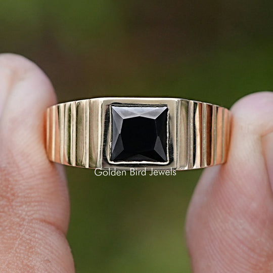 Princess Cut Black Gemstone Solitaire Men’s Ring Held Between Fingers