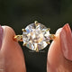 Two fingers holding the Old European Round Cut Moissanite Engagement Ring