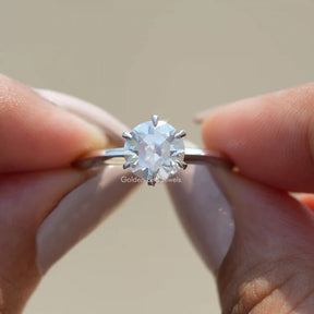 Two fingers holding the Old European Round Cut Moissanite Ring