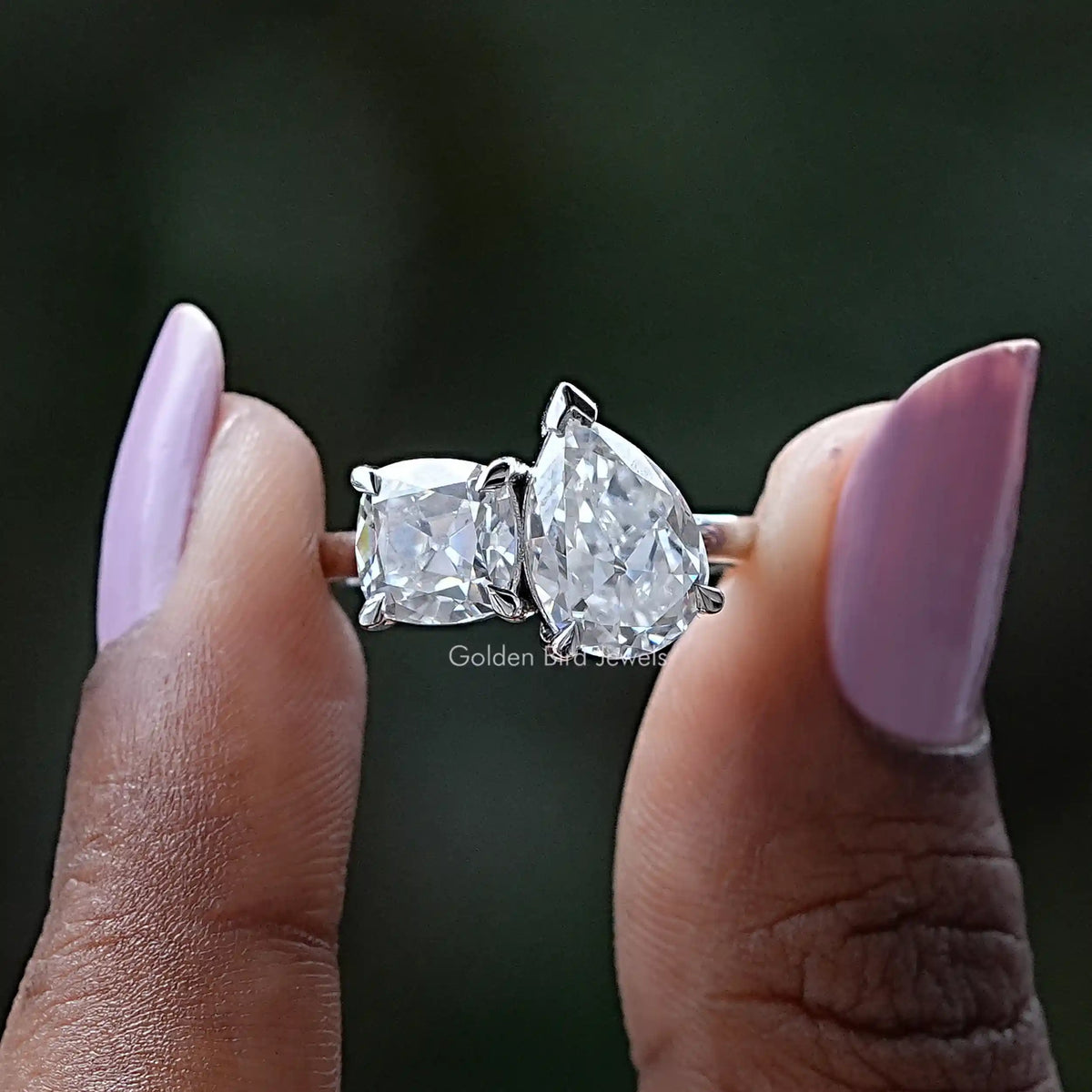 Front View of Cushion And Old Mine Pear Cut Moissanite Ring In two Fingers