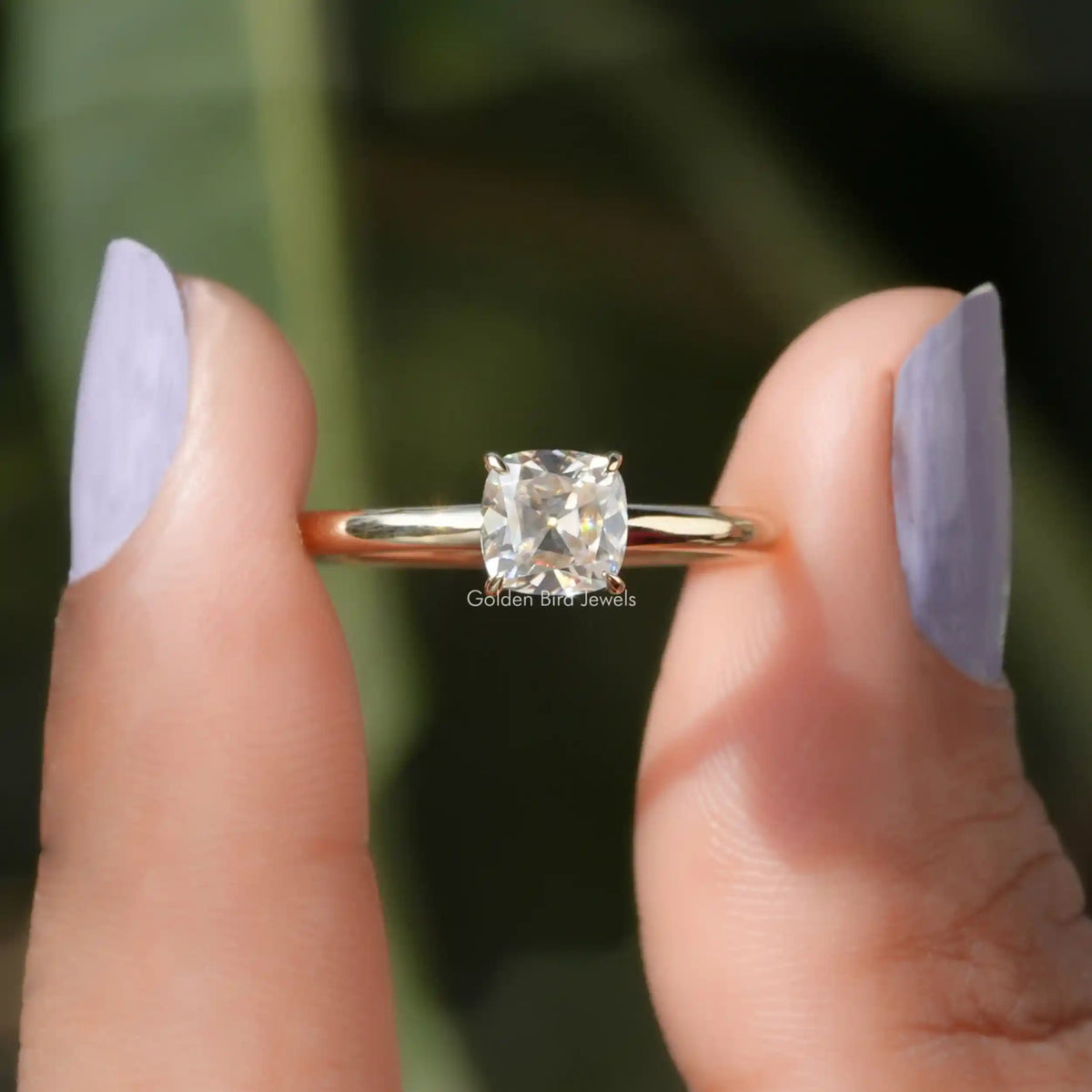 Two fingers holding the Cushion Cut Moissanite Solitaire Engagement Ring