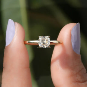 Two fingers holding the Cushion Cut Moissanite Solitaire Engagement Ring