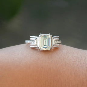 [This old mine emerald cut moissanite ring set in side round cut stones]