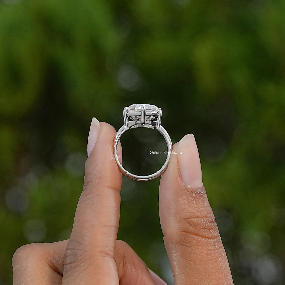 Sterling silver moissanite engagement ring viewed from the side, showing the raised setting and band.