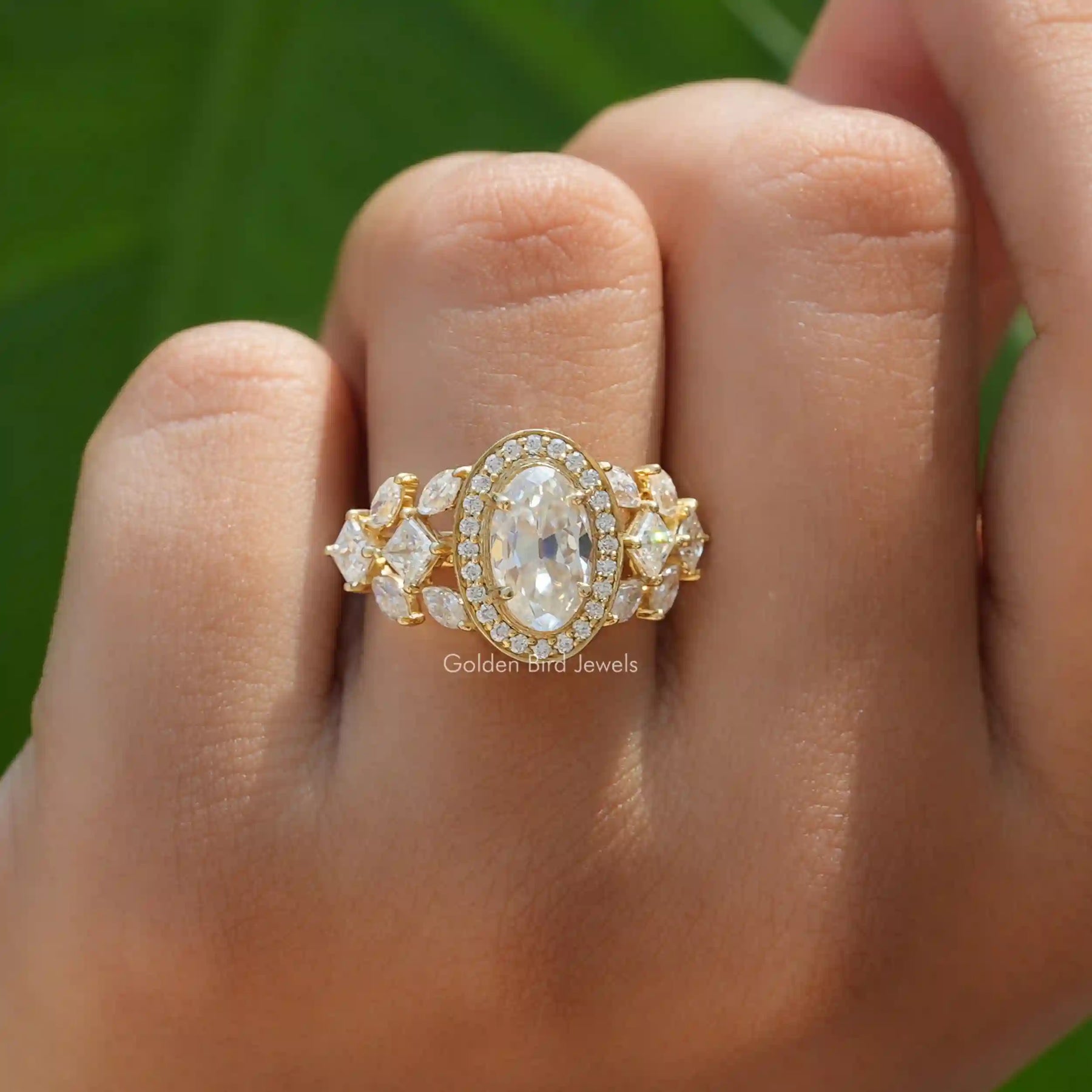 [This halo style moissanite engagement ring set in moval cut stone and side round cut stones]