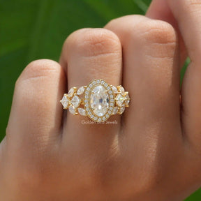 [This halo style moissanite engagement ring set in moval cut stone and side round cut stones]