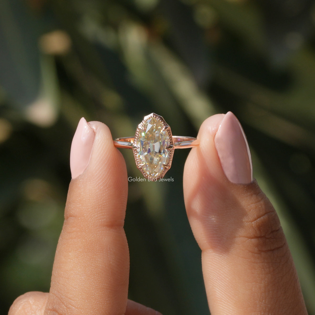 [In two finger front view of old mine moval cut moissanite solitaire engagement ring made of 14k yellow gold]-[Golden Bird Jewels]