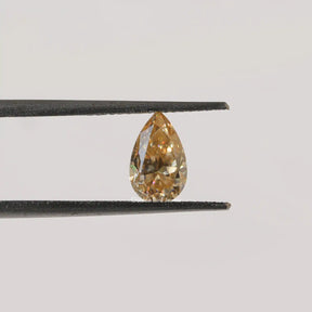 Twijer holding On the Old Mine Pear Cut Moissanite Stone