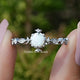 Front view of Opal Round Gemstone Accent Set Engagement Ring Set in two fingers 
