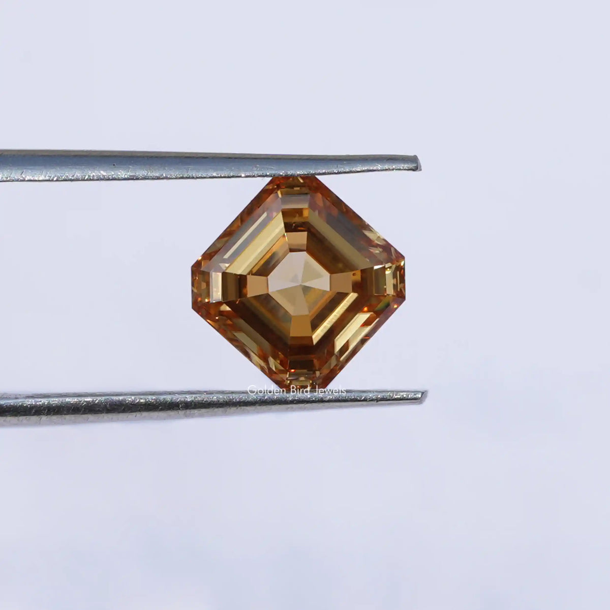 Twijer holding On the Orange Asscher Cut Loose Moissanite Stone