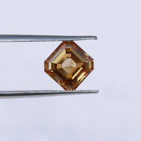 Twijer holding On the Orange Asscher Cut Loose Moissanite Stone