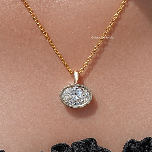 Oval lab diamond bezel pendant on yellow gold chain, round bezel setting, clear stone