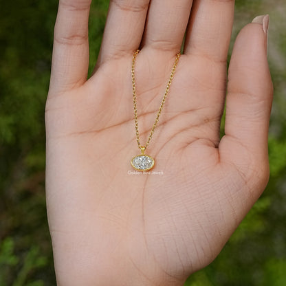 Gold-tone oval lab diamond solitaire pendant necklace on open hand