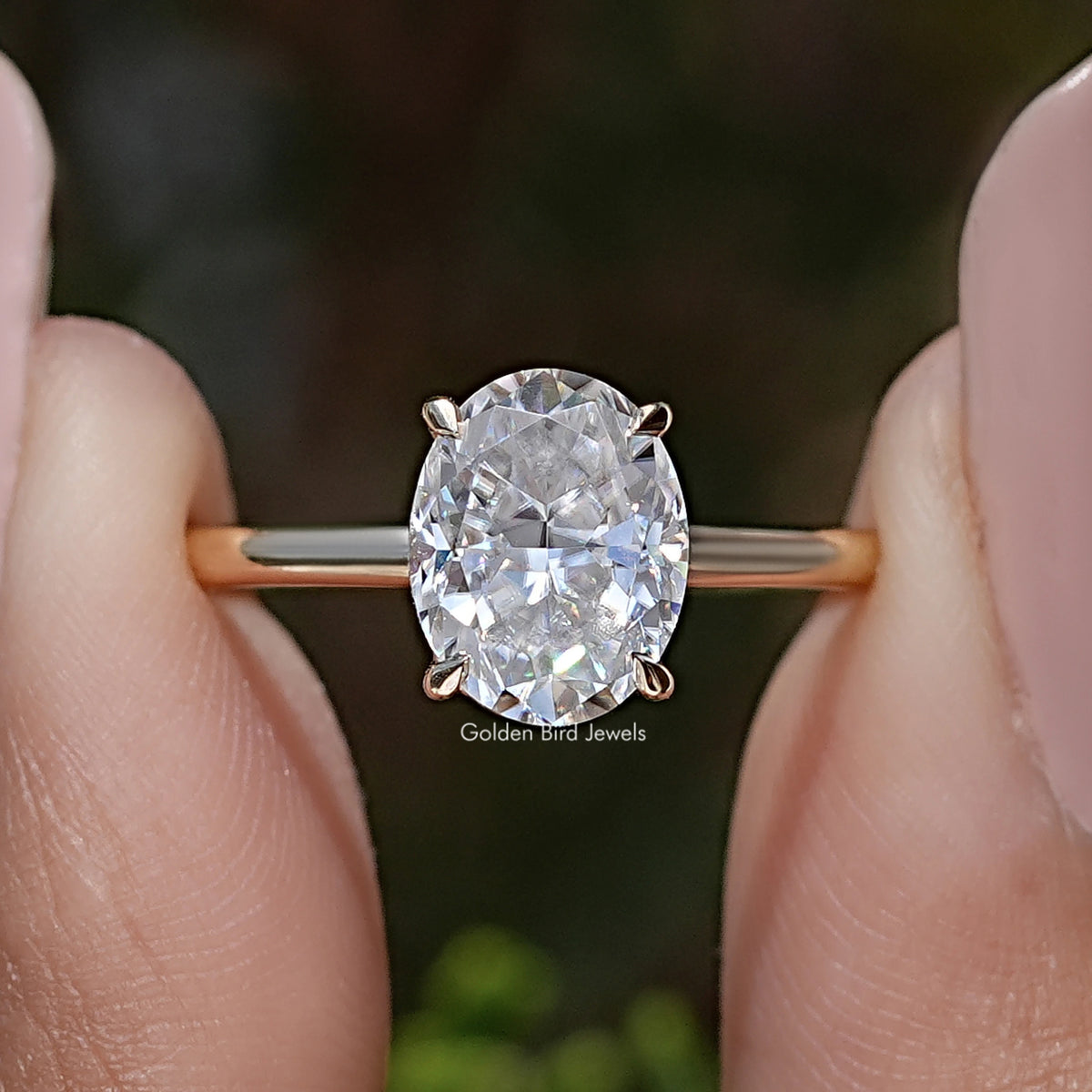 Gold-tone oval moissanite ring with four-prong setting and crushed-ice facets