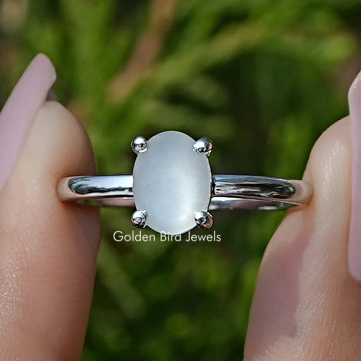 Front view of Oval Moonstone Gemstone Solitaire Ring in two fingers 