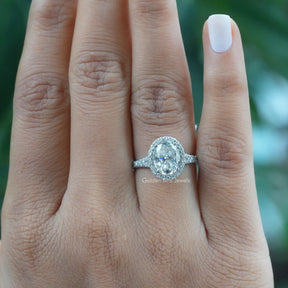 [In finger front view of oval cut halo moissanite engagement ring in 14k white gold]-[Golden Bird Jewels]