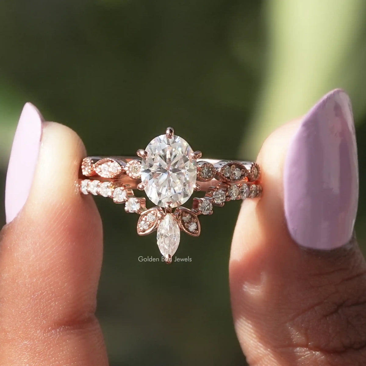 Two fingers holding the Oval Cut Moissanite Bridal Ring Set