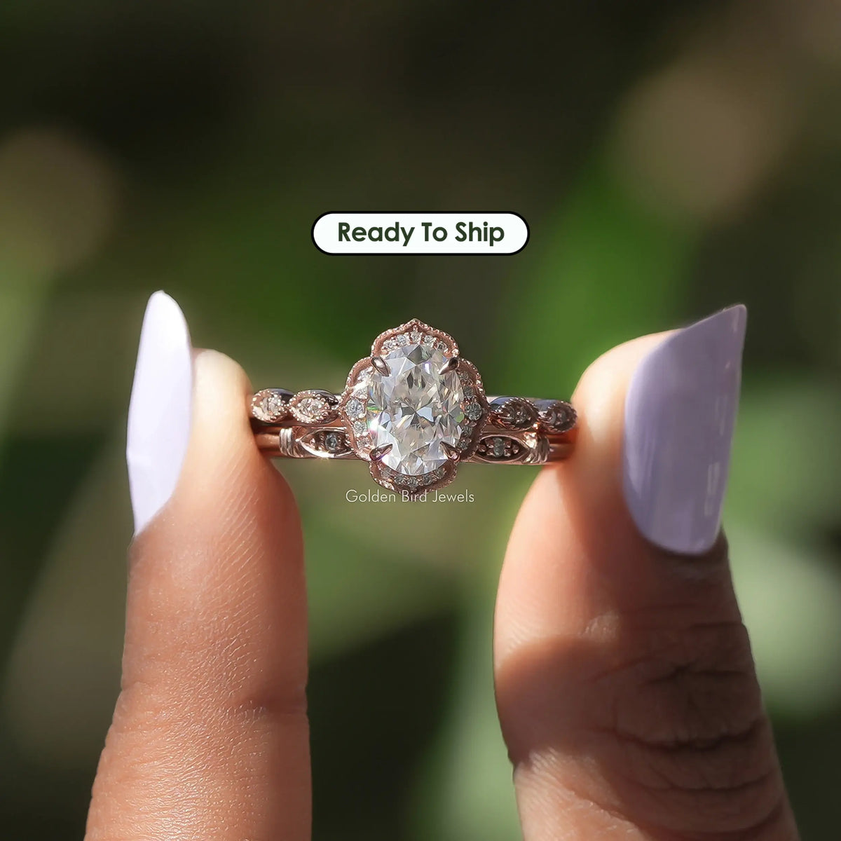 Two fingers holding the Oval Cut Moissanite Halo Wedding Ring