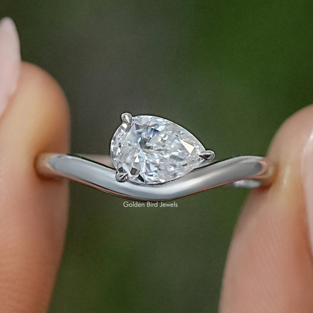 Pear-cut moissanite solitaire engagement ring on polished silver band