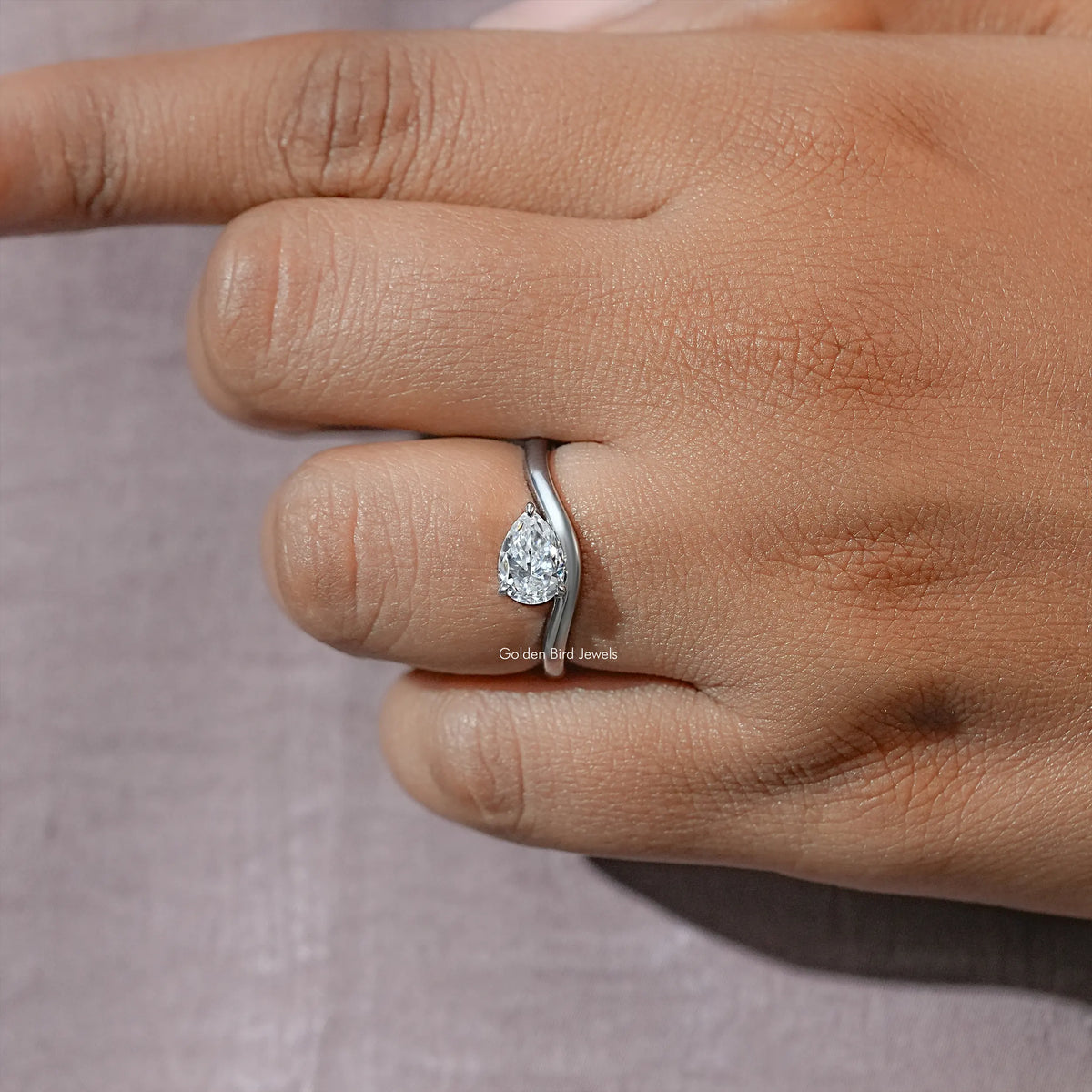 Close-up of pear-cut moissanite solitaire ring on finger