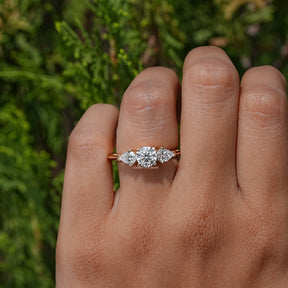 View of Pear And Round Cut Lab Diamond Three Stone Ring In Yellow Gold