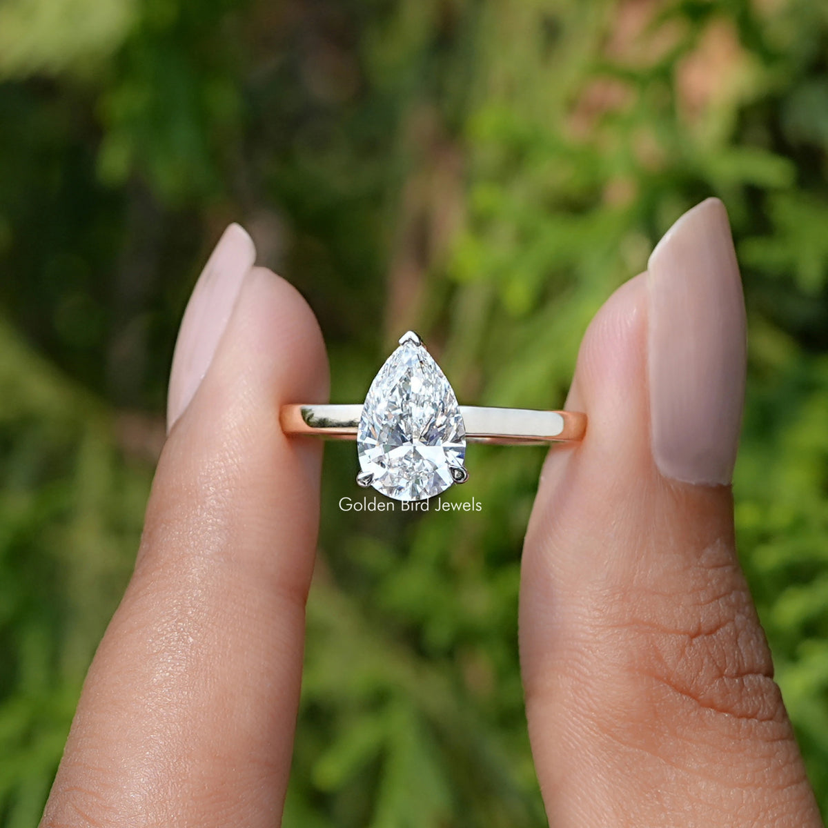 Front View of Pear Cut Lab Diamond Solitaire Engagement Ring In two Fingers