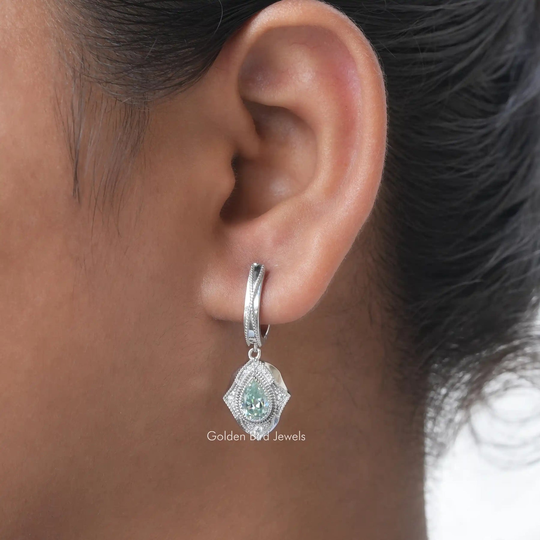 [In ear front view of blue pear moissanite earrings made of round cut side stones]-[Golden Bird Jewels]