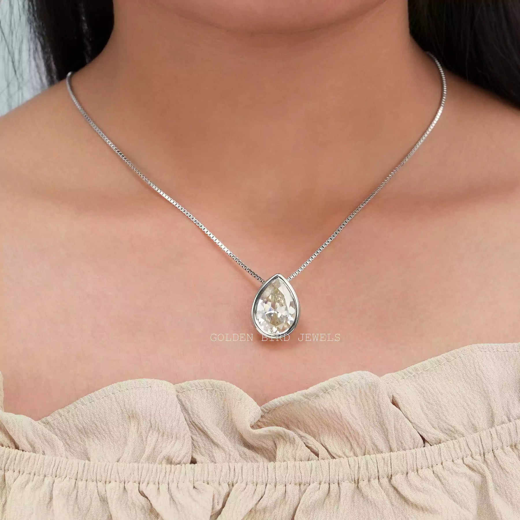 [In neck front view of bezel set pear cut moissanite pendant crafted with 14k white gold]-[Golden Bird Jewels]