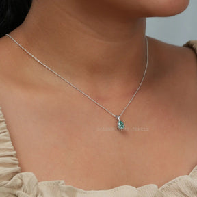 In neck side view of blue pear cut moissanite pendant