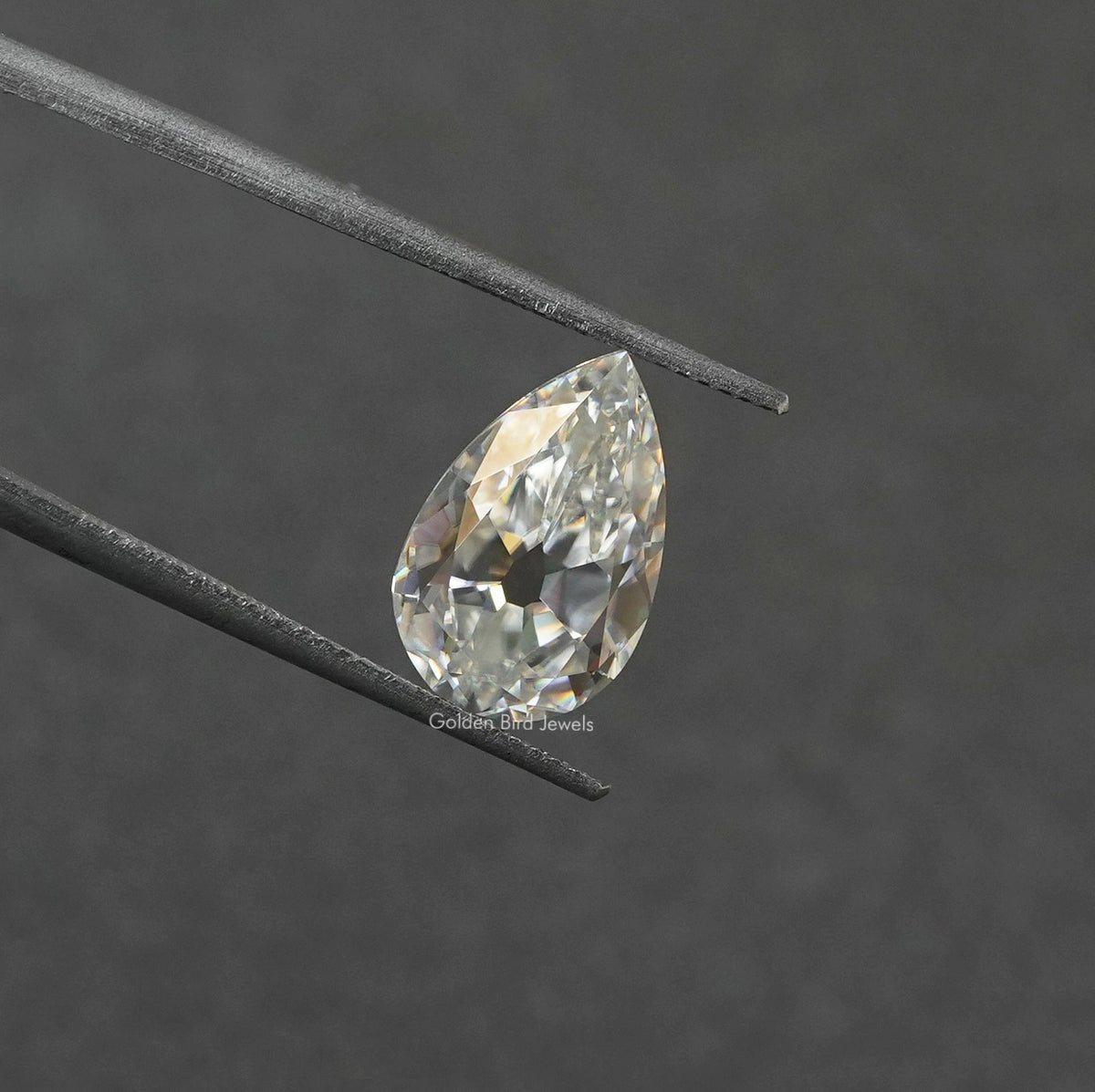 Tweezer view of Off White Old Mine Pear Cut Loose moissanite 