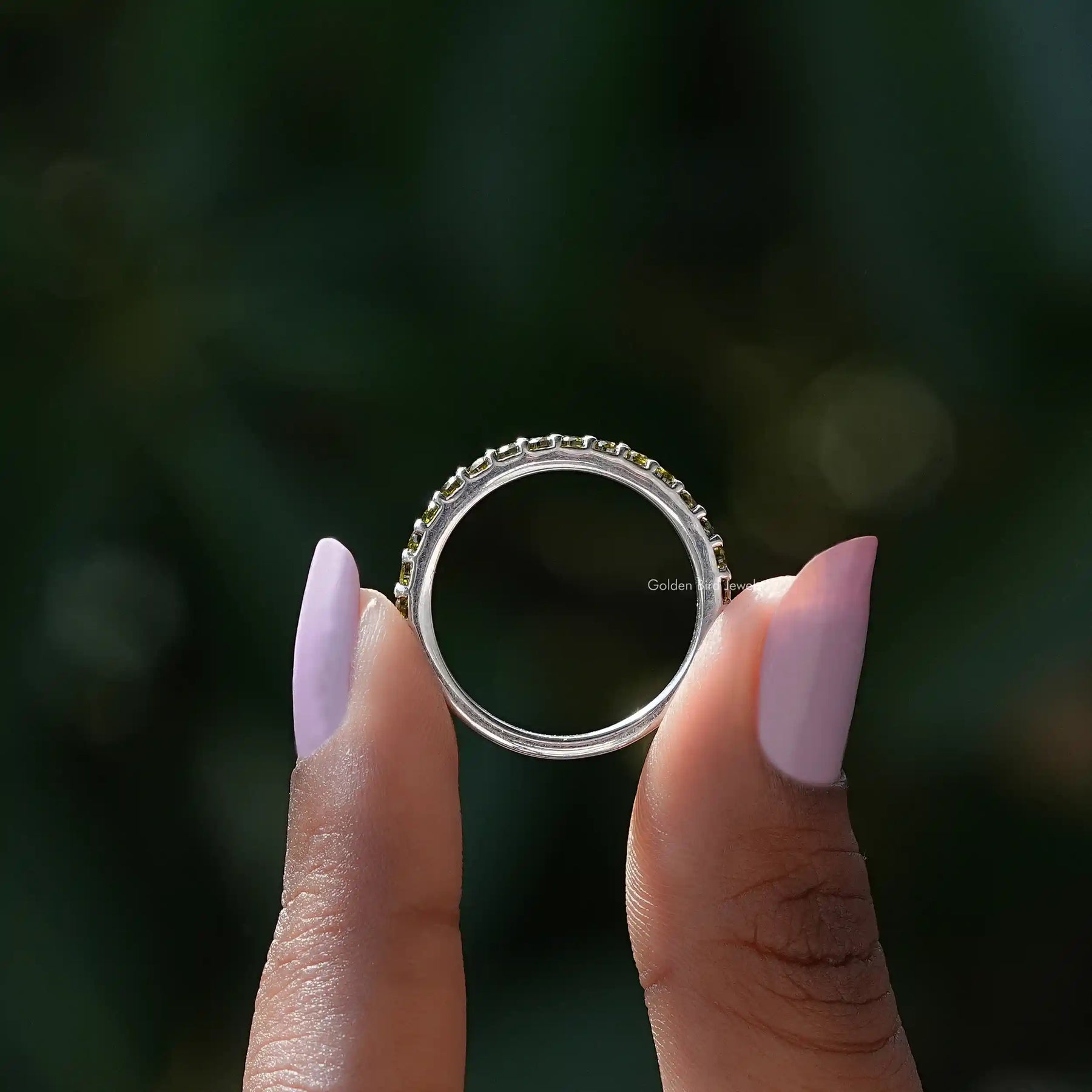 Back view of Green Round Eternity Band in secure setting