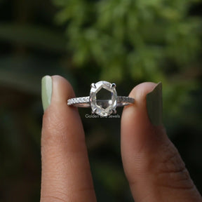 Two fingers holding the Portrait Cut Oval Moissanite Accent Ring