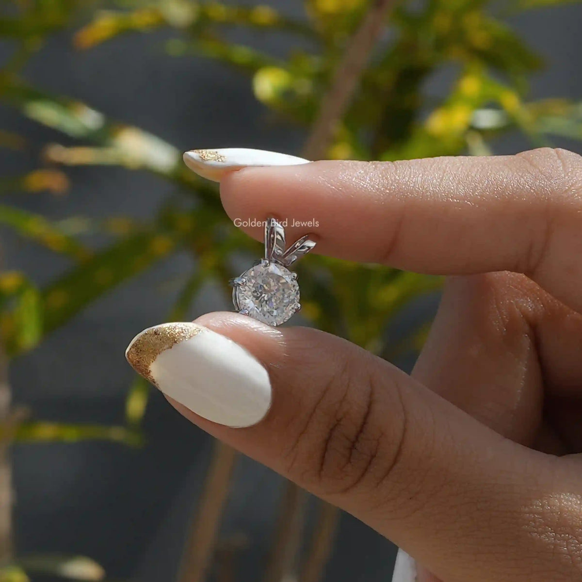 [In two finger front view of white gold Portuguese cut moissanite pendant 