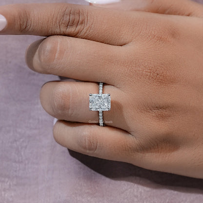 Close-up radiant cut square moissanite solitaire ring on fingertip, silver band