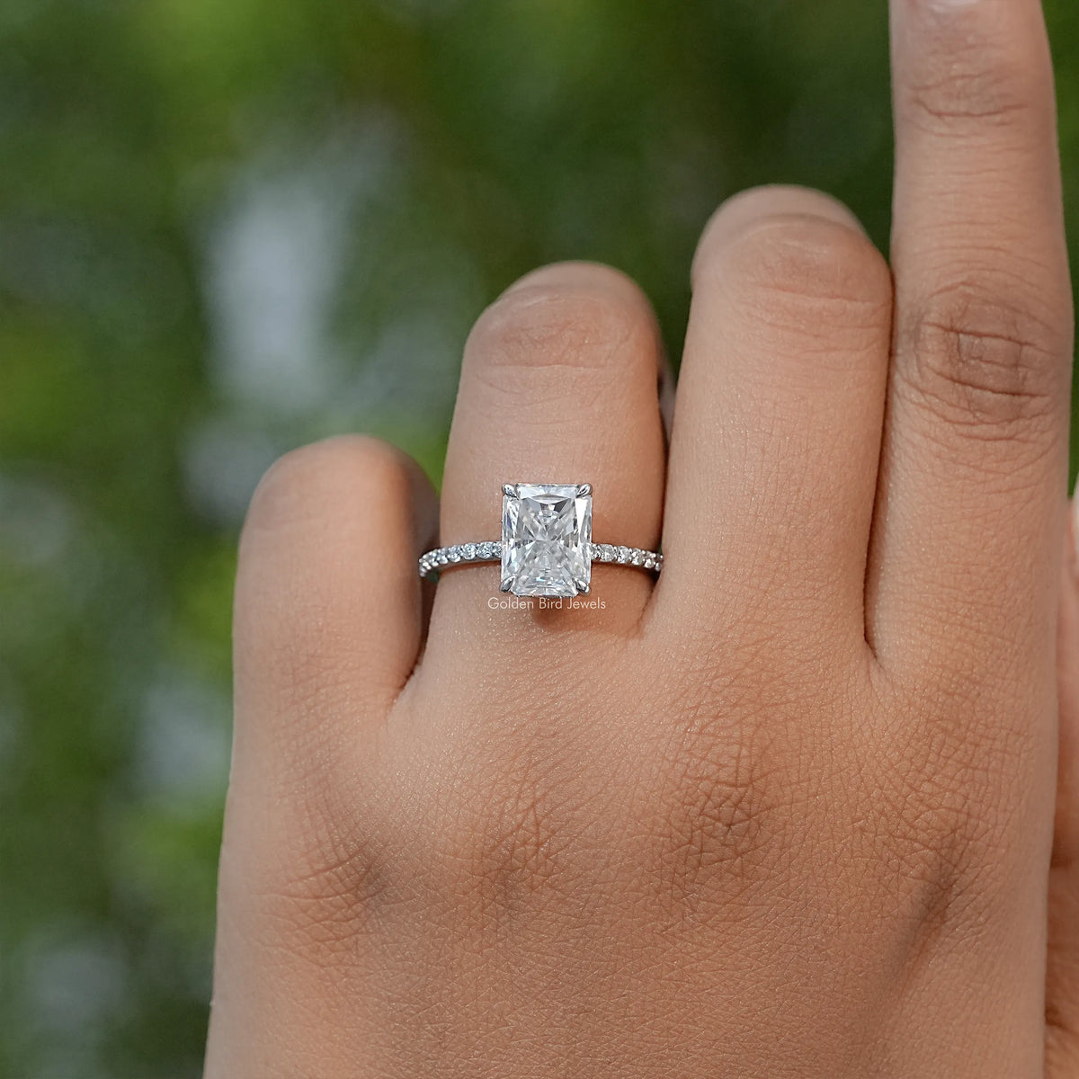 Square moissanite solitaire ring on finger, slim silver band with small stone accents