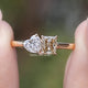 Front view of Radiant And Heart Cut Moissanite Two Stone Ring in two fingers 
