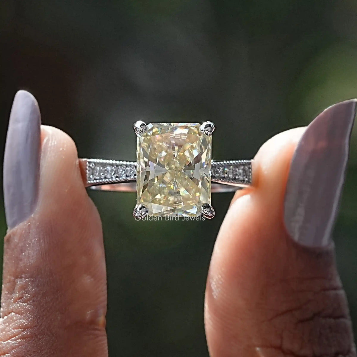 Two fingers holding the Radiant Cut Moissanite Accent Stone Ring