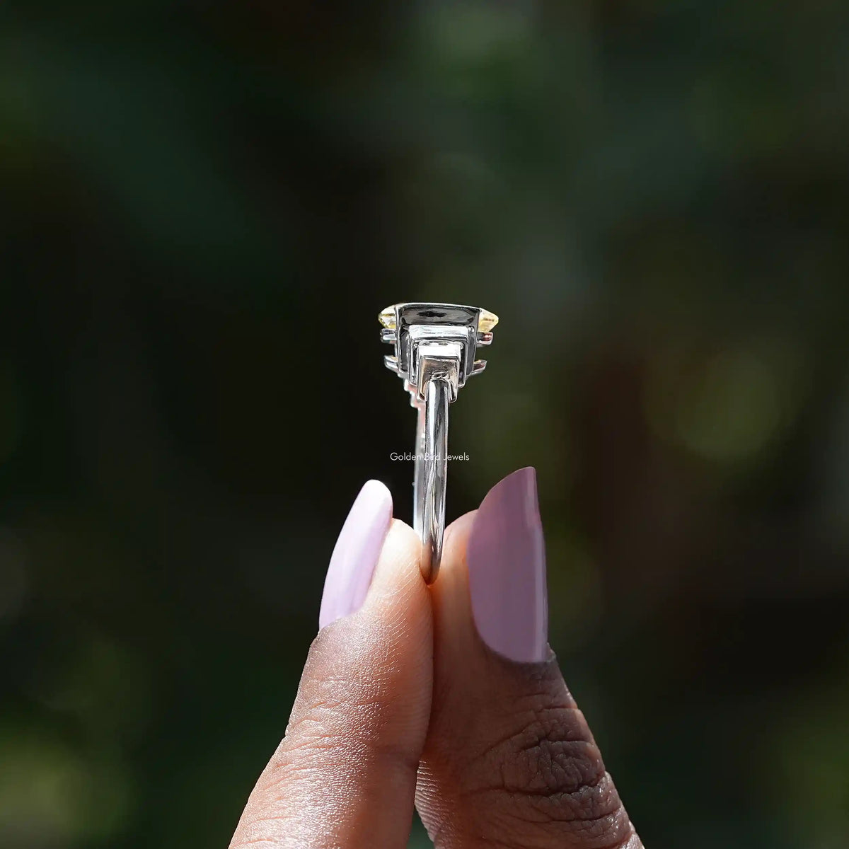 Side View of Radiant And Baguette Cut Half Bezel Set Ring In two fingers
