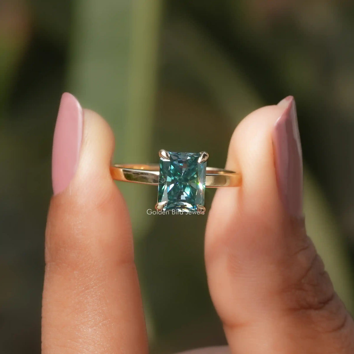 Two fingers holding the Radiant Cut Solitaire Moissanite Ring