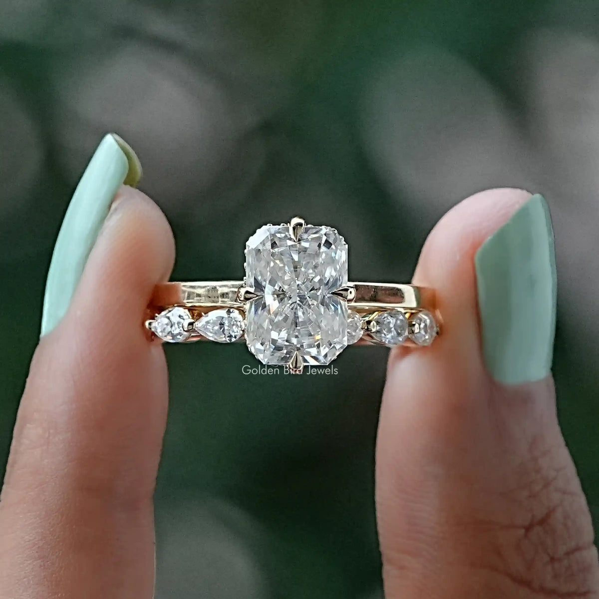 Two fingers holding the Radiant Cut Moissanite Engagement Ring