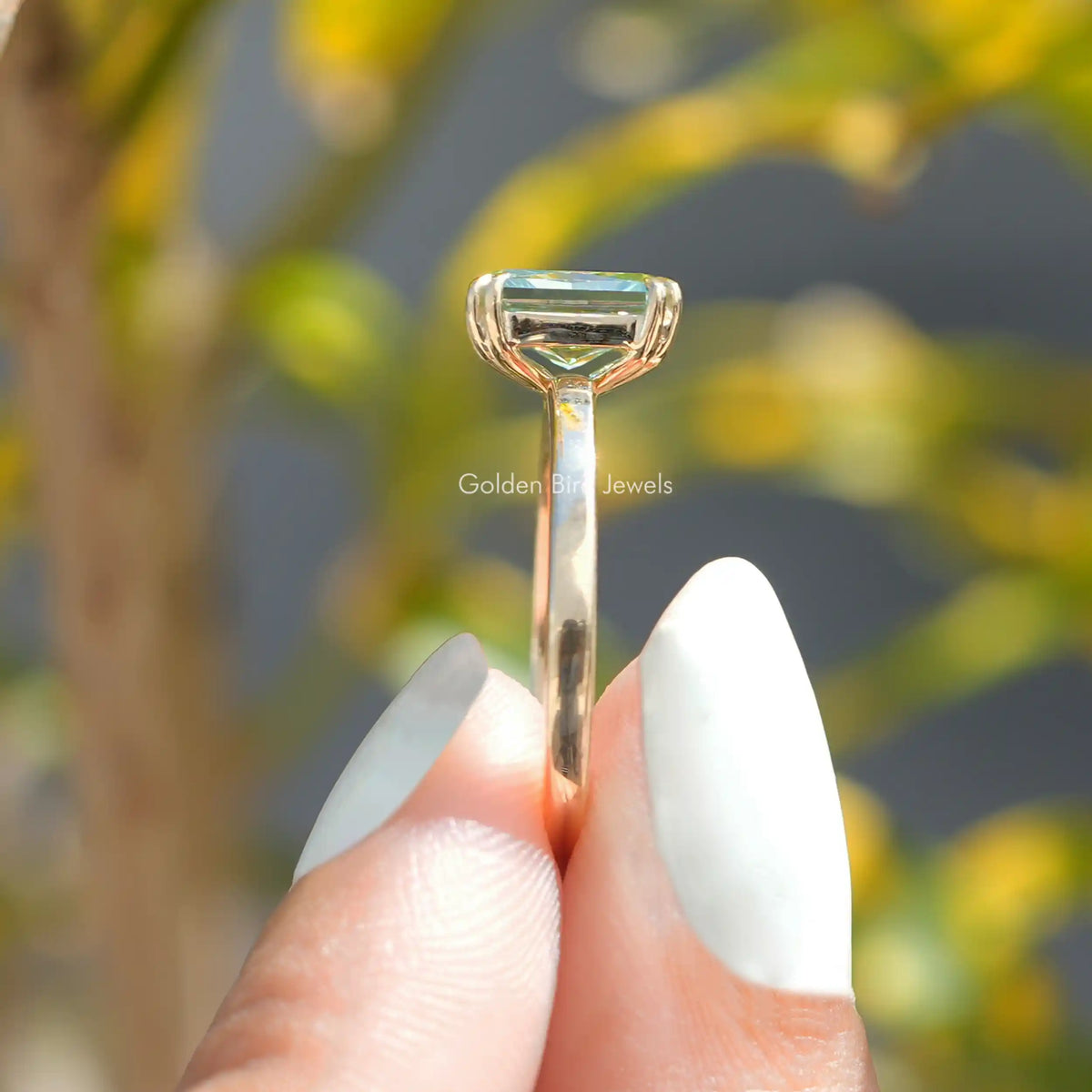Side Stone View A Radiant Cut  Engagement Ring In a two fingers
