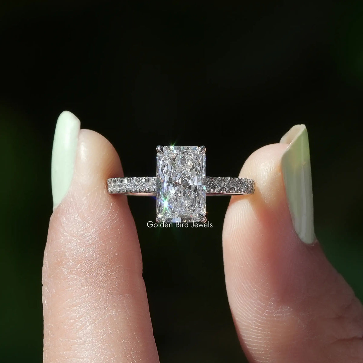 Two fingers holding the Radiant Cut Solitaire Accent Diamond Ring