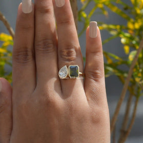 [In finger front view of moissanite two stone ring set in pear & radiant cut stones]