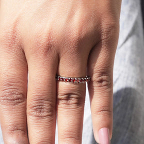 In finger front view of Red Garnet Round Gemstone Half Eternity Band in unique shape