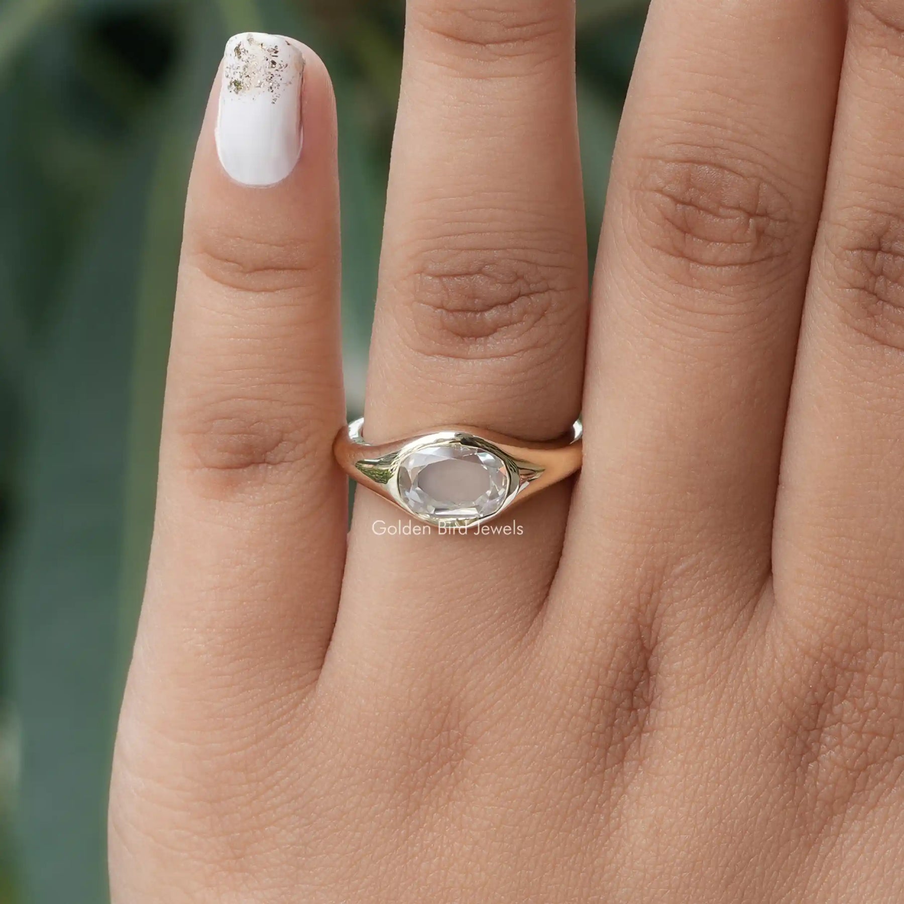 [In finger front view of oval cut moissanite ring made of bezel setting]-[Golden Bird Jewels]