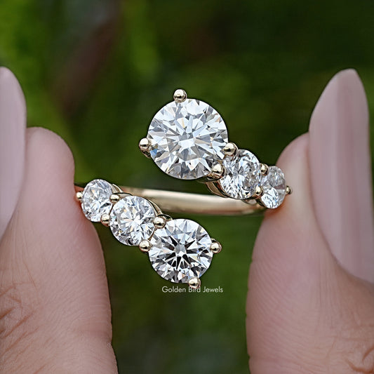 Silver-toned bypass ring with five round moissanite stones, prong-set on open shank