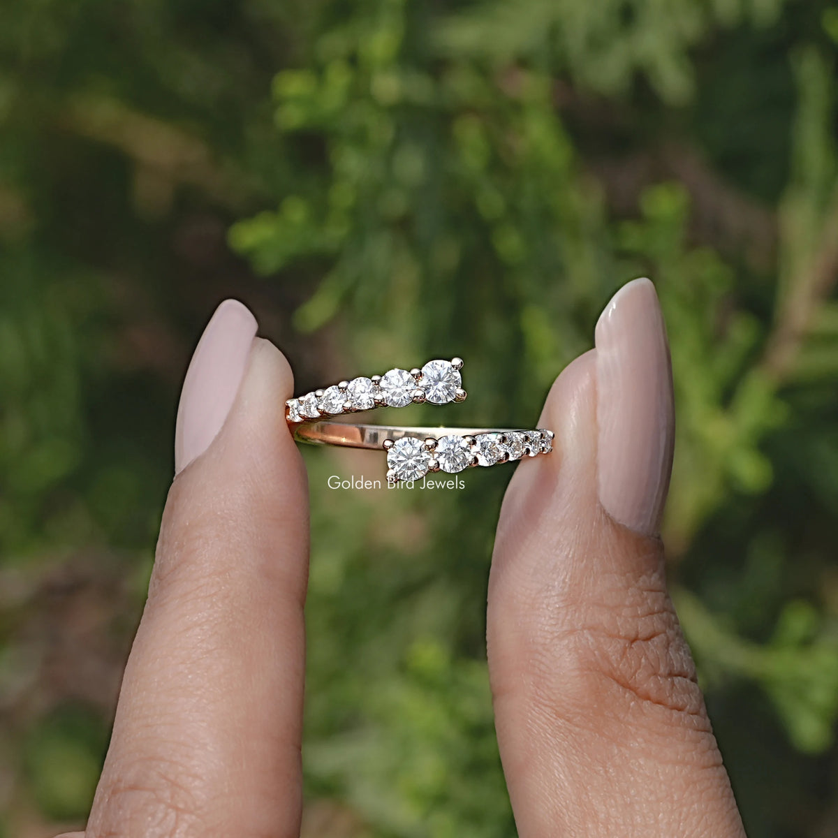 Front view of Round Cut Moissanite Open Wrap Bypass Ring in two fingers 