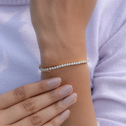 Silver-tone tennis bracelet with round-cut stones on wrist