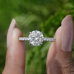 Front View of A Round Cut Lab Diamond Solitaire Ring In two fingers