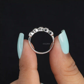 [In two finger front view of round cut moissanite 5 stone ring set in bezel setting]-[Golden Bird Jewels]